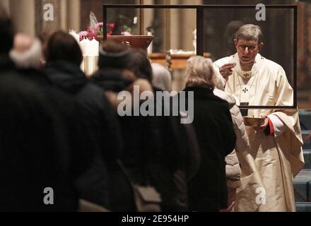 Köln, Deutschland. Februar 2021. Kardinal Rainer Maria Woelki (r), Erzbischof von Köln, feiert die heilige Kommunion mit den Gläubigen während eines Gottesdienstes im Dom. Quelle: Oliver Berg/dpa/Alamy Live News Stockfoto