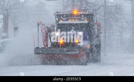 Eine Schneepflüge, die in einem Sturm arbeitet und der Schnee während eines Schneesturms auf Long Island Anfang Februar 2021 fällt. Stockfoto