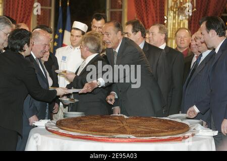 Der französische Präsident Jacques Chirac schneidet am 12. Januar 2006 im Elysee-Palast in Paris, Frankreich, ein Stück traditionelle Dreikönigskuchen, als die First Lady Bernadette Chirac und der Präsident des Nationalen Bäckereiverbands Pierre Crouzet (2. R) zuschauen. Foto von Mousse/ABACAPRESS.COM Stockfoto