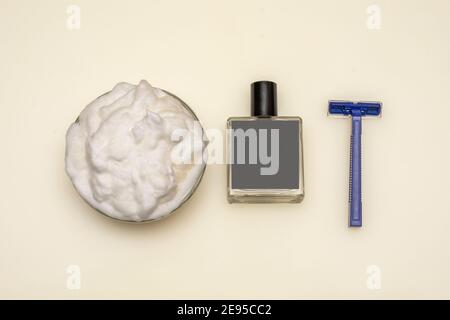 Rasierprodukte für Männer: Schaum, Rasiermesser und Aftershave mit unbeschrifttem Etikett. Draufsicht, weißer Hintergrund, Branding-Mockup. Stockfoto