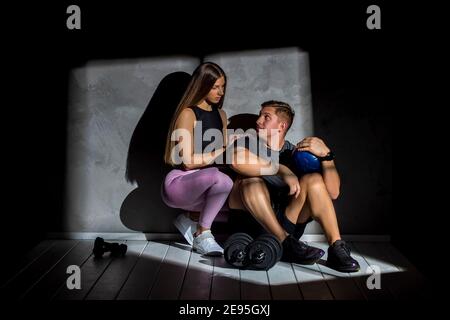 Attraktive junge Paar im Sport tragen dabei Übung in der Turnhalle. Stärke und Motivation Stockfoto