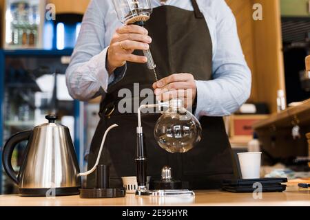 Syphon alternative Methode der Herstellung von Kaffee. Barista bereitet das Gerät für die Zubereitung von Kaffee im Café vor. Skandinavische Methode der Kaffeeherstellung. Stockfoto