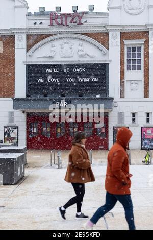 Bei starkem Schnee passieren die Menschen das geschlossene Kino, Windrush Square, Brixton, London, 24. Januar 2021 Stockfoto