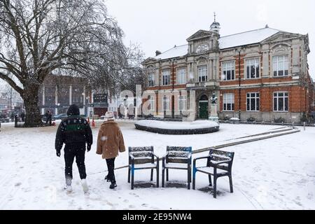 Menschen wandern durch den Windrush Square bei starkem Schnee mit der Brixton Library im Hintergrund, Brixton, London, 24. Januar 2021 Stockfoto