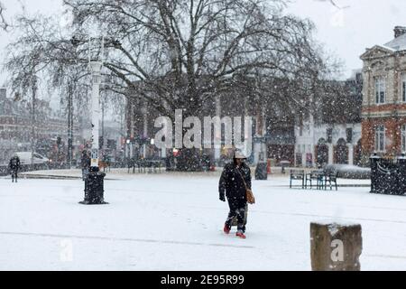 Eine Frau geht bei starkem Schnee über den Windrush Square, Brixton, London, 24. Januar 2021 Stockfoto