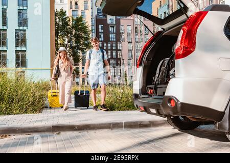 Paar sammeln für Road Trip. Putting Taschen auf Auto-Kofferraum. Sommerferien Stockfoto