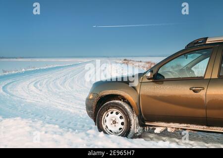 Gefrorene und grungy SUV Auto auf Winter Snowy Field Landschaft geparkt. Veränderter Himmel Mit Flugzeug Stockfoto