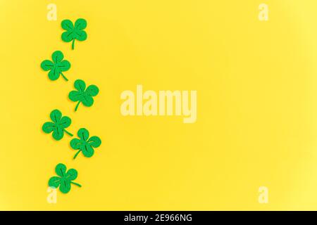 St. Patricks Day Hintergrund. Einfach minimalistisches Design mit grünem Kleeblatt. Kleeblätter isoliert auf gelbem Hintergrund. Symbol von Irland. Glück w Stockfoto