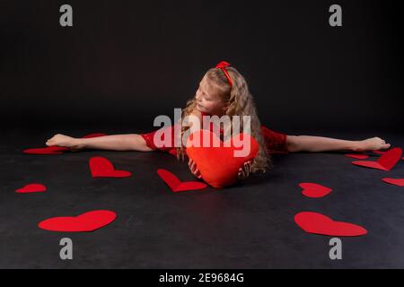 In Garn in den Händen des Herzens Papierherzen glücklich, glücklich, auf dem Boden Herzen schön. Die Inspiration des Anlasses. Für immer, Geschenk in rotem Kleid Stockfoto