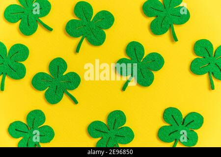 St. Patricks Day Hintergrund. Einfach minimalistisches Design mit grünem Kleeblatt. Kleeblätter isoliert auf gelbem Hintergrund. Symbol von Irland. Glück w Stockfoto