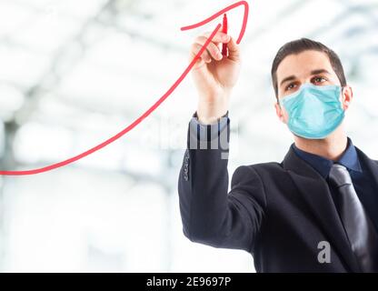 Masked Geschäftsmann Zeichnung einen steigenden Pfeil für das Wachstum des Unternehmens während Covid Coronavirus Pandemie Stockfoto