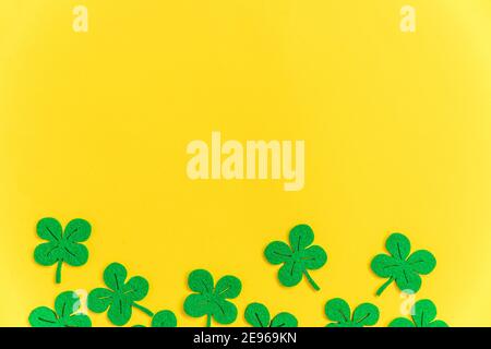 St. Patricks Day Hintergrund. Einfach minimalistisches Design mit grünem Kleeblatt. Kleeblätter isoliert auf gelbem Hintergrund. Symbol von Irland. Glück w Stockfoto