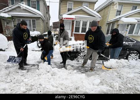 New York, USA. Februar 2021. Community Volunteers from Brooklyn Teen Challenge der klare Schnee vor einem geparkten Auto nach einem Wintersturm brachte mehr als 17 Zoll Schnee in Teile der Stadt, in Queens Bezirk von New York City, NY, 2. Februar 2021. (Foto von Anthony Behar/Sipa USA) Quelle: SIPA USA/Alamy Live News Stockfoto