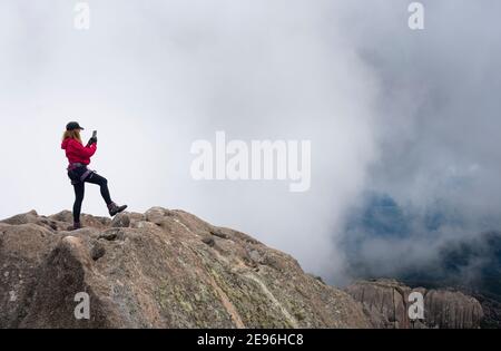 Frau auf dem Gipfel des Berges macht ein Selfie Stockfoto