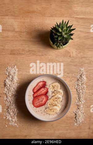 Pürierte Haferflocken mit Erdbeer- und Bananenscheiben. Appetitlich veganes Essen. Stockfoto