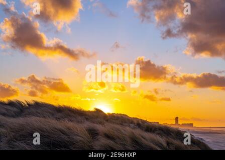 Sonnenuntergang gesehen von Sanddünen in Ostende (Oostende) bei Sonnenuntergang mit der Skyline der Stadt im Hintergrund, Belgien. Stockfoto