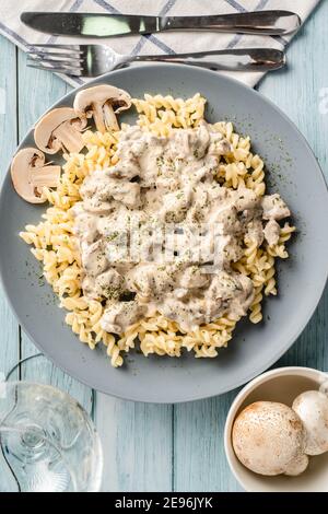 Tagliatelle Italienische Pasta mit Wald weißen Champignon Pilze cremige Sauce Und Huhn oder Rindfleisch - hausgemachte Speisen auf dem Teller Auf der Tischansicht Stockfoto