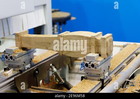 Moderne Holzbearbeitungsmaschine in einer Möbelfabrik. Herstellung von gefrästen Tischbeinen mit CNC-Maschine. Selektiver Fokus. Stockfoto