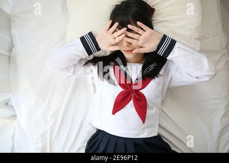 Portrait japanisch Schule Mädchen schlafen mit Kissen in weißen Ton Schlafzimmer Stockfoto