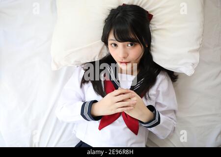 Portrait japanisch Schule Mädchen schlafen mit Kissen in weißen Ton Schlafzimmer Stockfoto