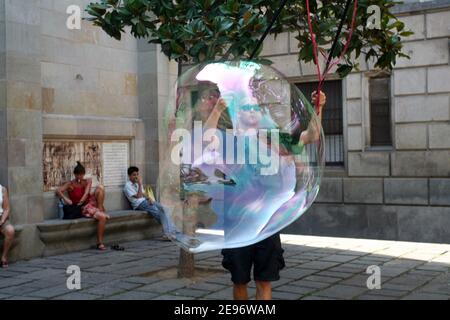 BARCELONA, SPANIEN - AUGUST 14: Street Performer macht große Ballons an der berühmten Straße La Rambla am 14. August 2009 in Barcelona, Spanien. Tausende von Menschen gehen täglich an dieser beliebten Fußgängerzone mit einer Länge von 1,2 Kilometern vorbei. Stockfoto