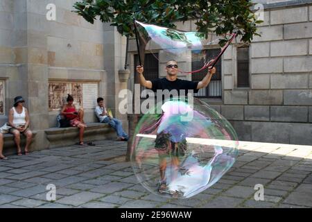 BARCELONA, SPANIEN - AUGUST 14: Street Performer macht große Ballons an der berühmten Straße La Rambla am 14. August 2009 in Barcelona, Spanien. Tausende von Menschen gehen täglich an dieser beliebten Fußgängerzone mit einer Länge von 1,2 Kilometern vorbei. Stockfoto