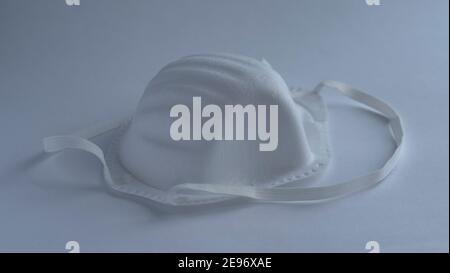 Eine medizinische Gesichtsmaske mit Schutzbrille auf weißem Hintergrund, isoliert, Konzept Epidemie Coronavirus Stockfoto