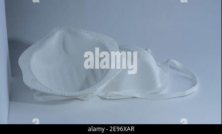 Eine medizinische Gesichtsmaske mit Schutzbrille auf weißem Hintergrund, isoliert, Konzept Epidemie Coronavirus Stockfoto