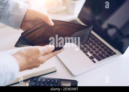 Frau hält eine leere Geldbörse und Münzen in der Hand bedeutet Geld finanzielle Problem oder bankrott ohne Arbeit, brach nach Kreditkarte Zahltag ohne Arbeit, Schulden Konzept Stockfoto