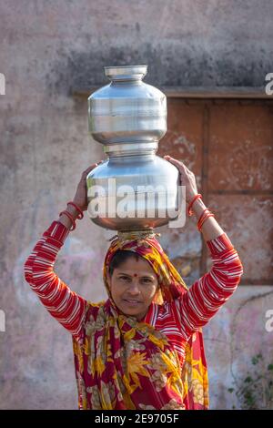 TIKAMGARH, MADHYA PRADESH, INDIEN - 23. JANUAR 2021: Eine indische Frau, die einen Behälter mit Wasser auf dem Kopf trägt. Stockfoto