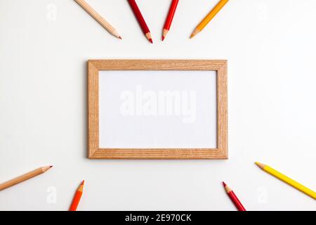 Gelb rot Bleistifte und Holzrahmen auf weißem Hintergrund. Flache Lay-Ansicht von oben. Bildung zurück in die Schule und Online-Studienkonzept mit Kopieplatz Stockfoto