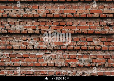 Die Textur einer alten Ziegelmauer mit natürlichen Defekten. Kratzer, Risse, Spalten, Späne, Staub, Rauheit, Abrieb. Vorlage für Design und Backgrou Stockfoto