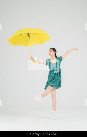 Asiatische weibliche zeitgenössische Tänzerin macht Bewegung mit unbrella Stockfoto