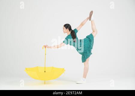 Asiatische weibliche zeitgenössische Tänzerin macht Bewegung mit unbrella Stockfoto