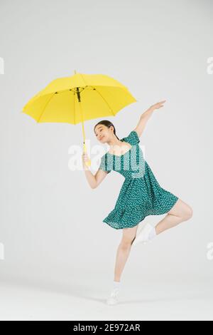 Asiatische weibliche zeitgenössische Tänzerin macht Bewegung mit unbrella Stockfoto