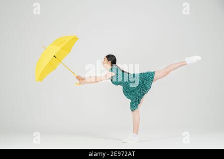 Asiatische weibliche zeitgenössische Tänzerin macht Bewegung mit unbrella Stockfoto