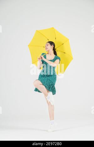 Asiatische weibliche zeitgenössische Tänzerin macht Bewegung mit unbrella Stockfoto