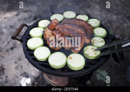 Würstchen und Squash auf dem Grill Stockfoto