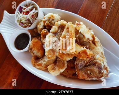 Gebratener Seebarsch mit Fischsauce. Gebratene Fischfilets die Schale mit dem Kopf und dem Fischbein anrichten. Thailändisches Essen. Stockfoto