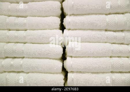 Stapel reiner weißer flauschiger Handtücher auf dem Regal Stockfoto