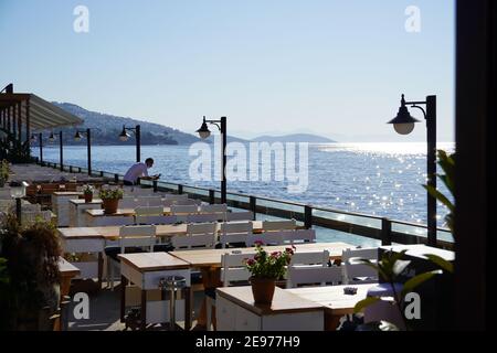 Café im Freien mit schickem Blick auf die Bucht, Seaside Holztisch und Stühle, offenes Café, Restaurant im Freien in Marina Bay, Bodrum - Türkei an der Küste Stockfoto