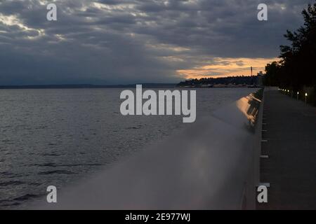 Seattle, WA-11,28.2018: Sonne untergeht in den wolkigen Himmel, der Elliot Bay mit ein paar Washington Inseln in der Ferne überblickt. Stockfoto