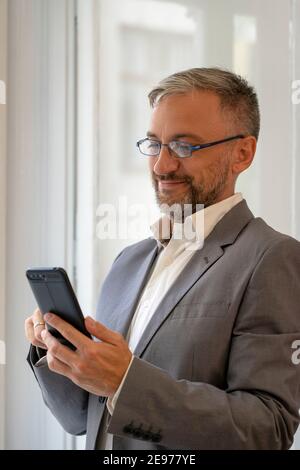 Handsome Reifen Geschäftsmann Mit Handy. Porträt von lächelnd mittleren Alters Geschäftsmann mit Handy. Stockfoto