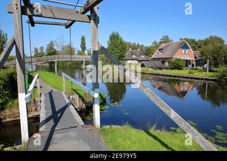 Dwarsgracht, ein malerisches Dorf auf dem Land bei Giethoorn, mit Wasserkanälen, Holzstegen und Häusern mit Strohdach, Niederlande Stockfoto