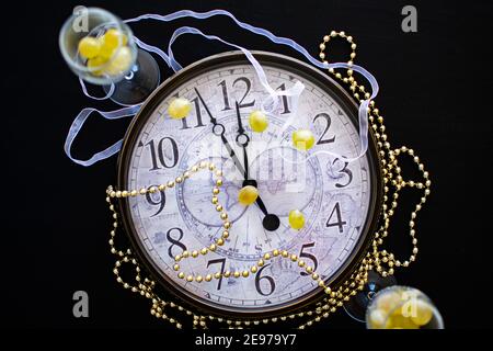 Ein Ziffernblatt, das kurz vor Mitternacht über neue Jahre zeigt eve in Spanien mit zwei Sektflöten mit zwölf Trauben Stockfoto