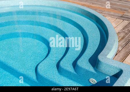 Neue moderne Fiberglas Kunststoff Schwimmbad Eingang Schritt mit sauber Frisches, erfrischendes blaues Wasser an einem heißen Sommertag Hof oder Resort Hotel Spa Stockfoto