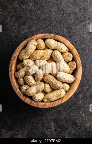 Getrocknete Erdnüsse. Leckere Erdnüsse in Schale auf schwarzem Tisch. Draufsicht. Stockfoto