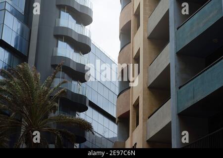 Betonfassade mit Balkonen im Kontrast zu EINEM Gebäude mit Glasfassade Stockfoto