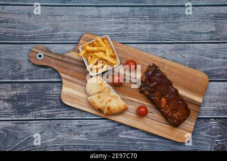 Flache Grillrippen mit pommes Frites und Kirsche Tomate Stockfoto