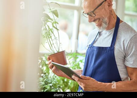 Kaukasischer Mann mittleren Alters, der Informationen auf der Tablette überprüft Stockfoto
